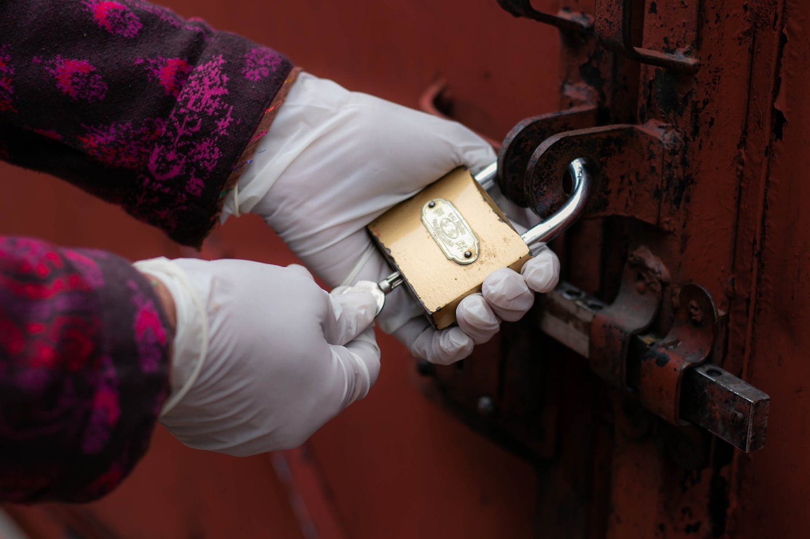person holding gold padlock with key